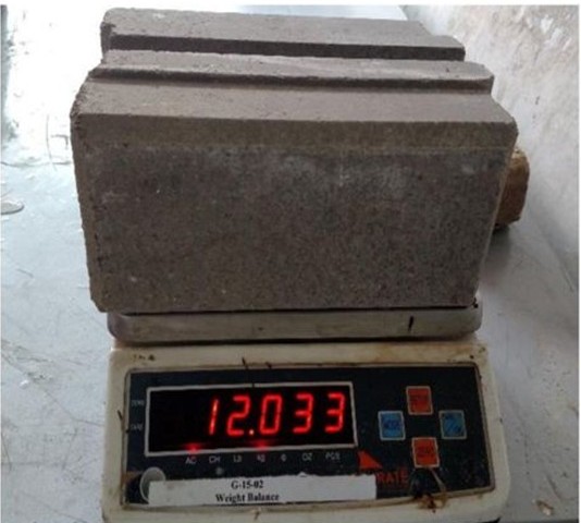 Solid Earths compressed stabilized earth block on a weighing balance